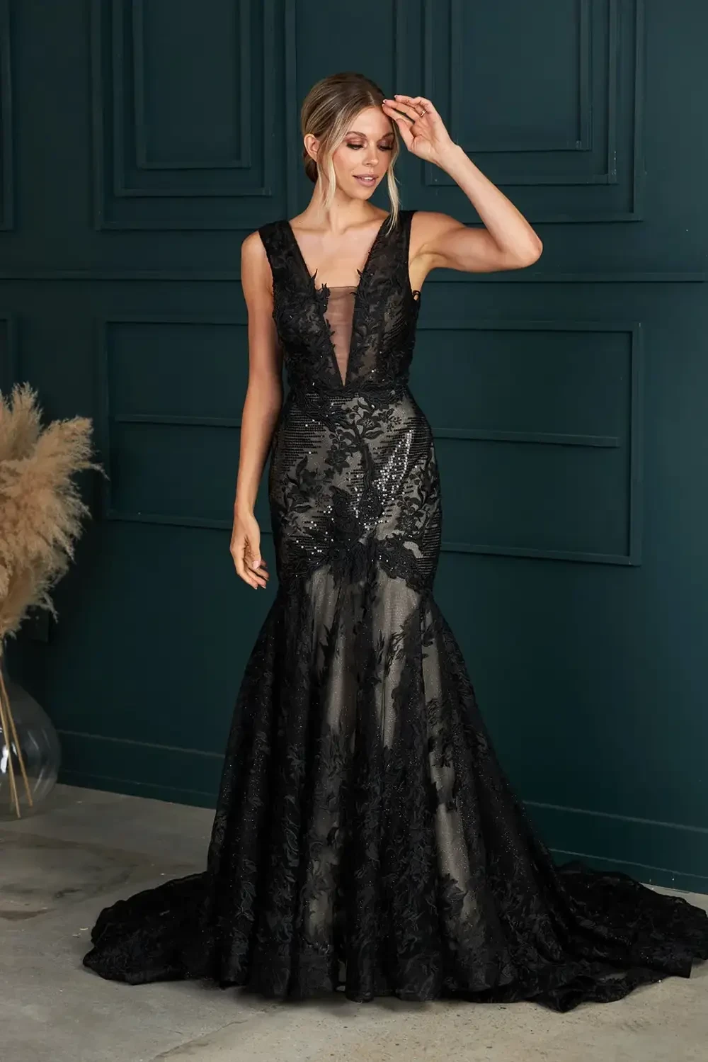 model is wearing a sleeveless black lace bridal gown