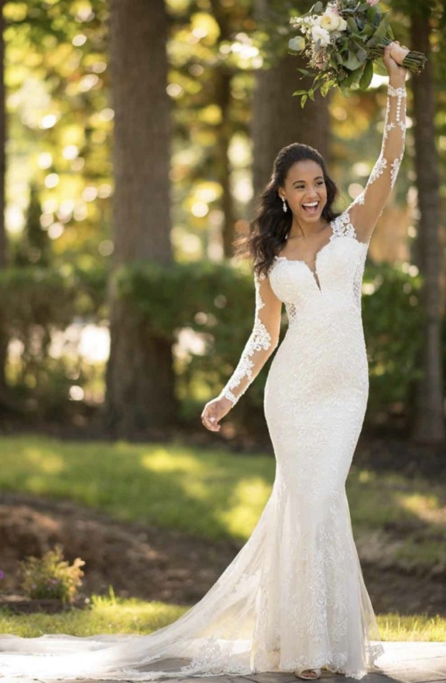 model is wearing an illusion long sleeve lace fit and flare wedding dress
