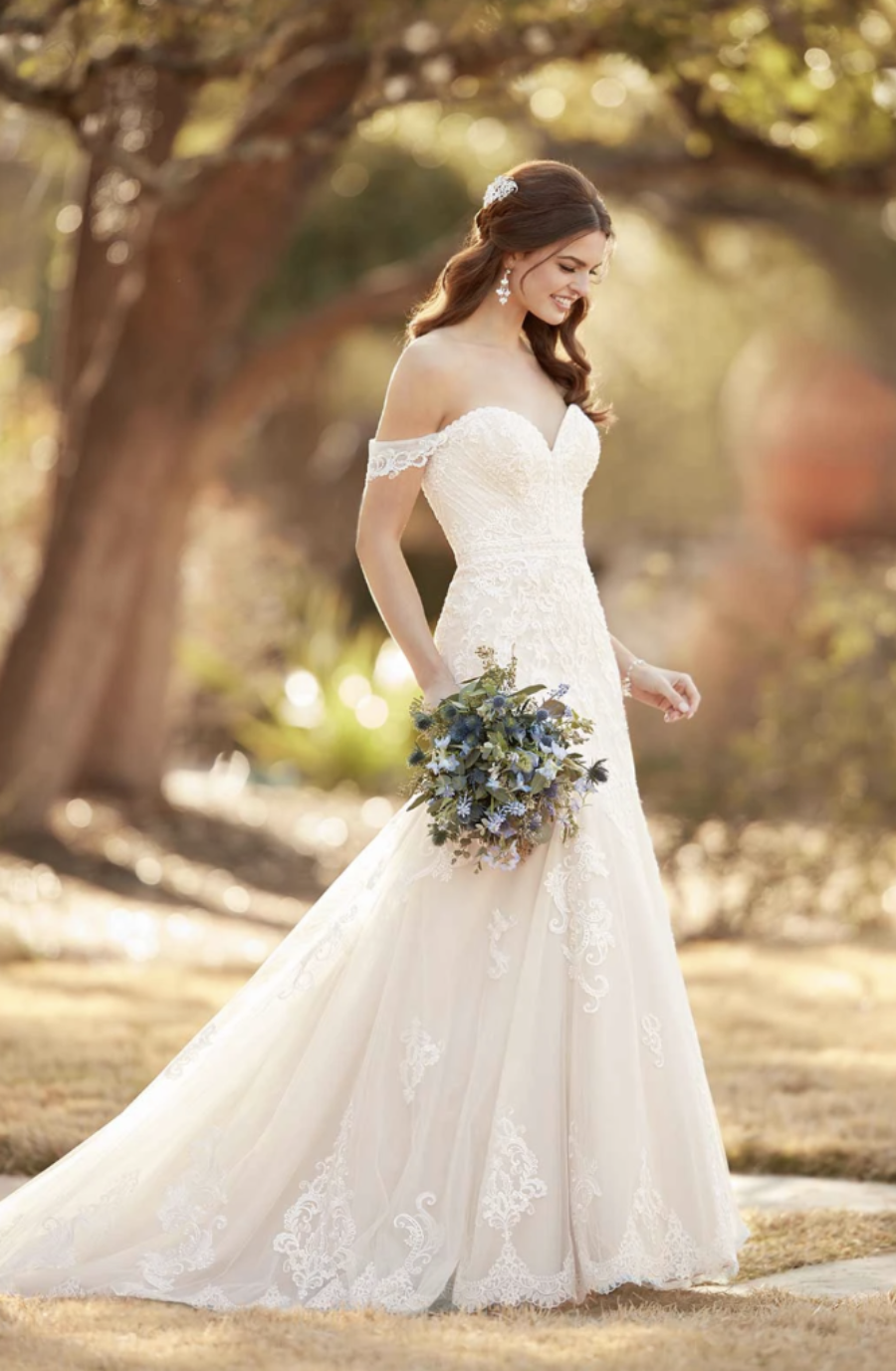 model is wearing an off the shoulder fit and flare bridal gown