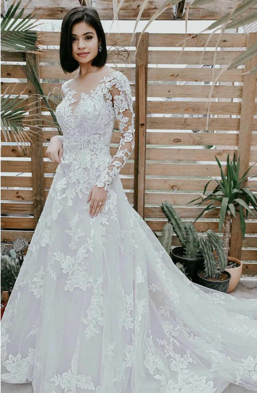 model is wearing a lace long sleeve a-line wedding dress
