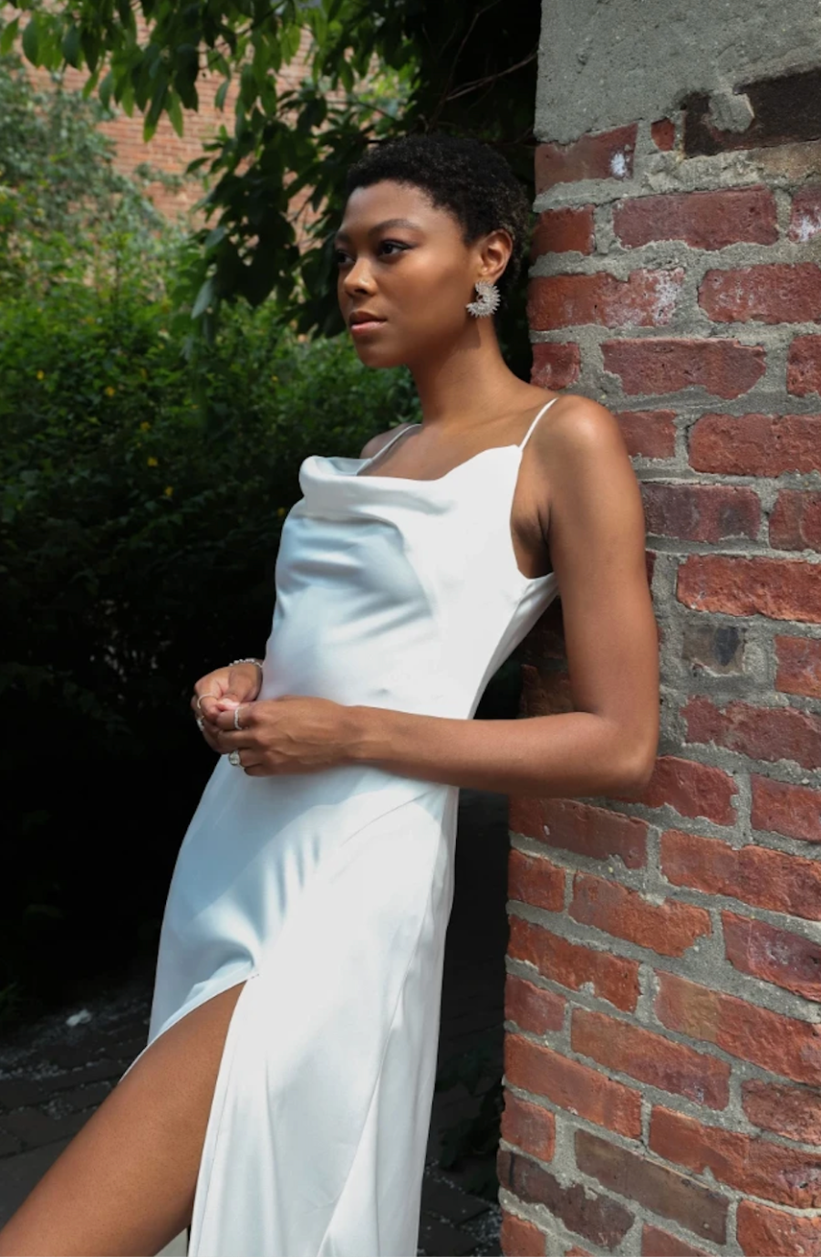 model is wearing a sleeveless satin bridal gown